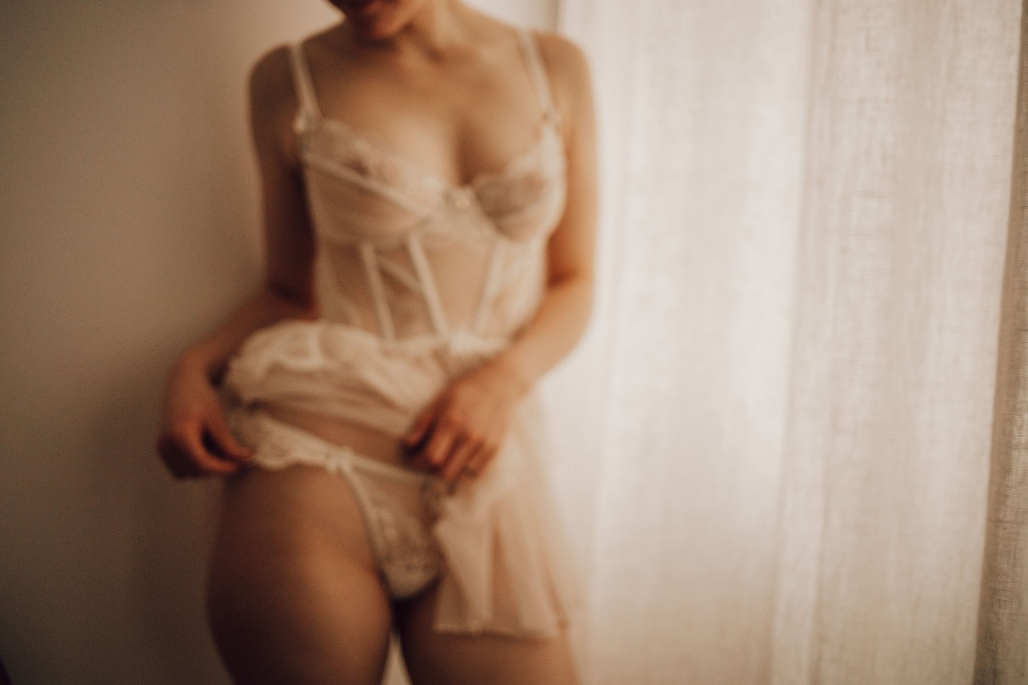 Portrait lingerie voilée devant la fenêtre
