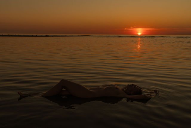 Silhouette flottant sur l'eau, lumière du soir
